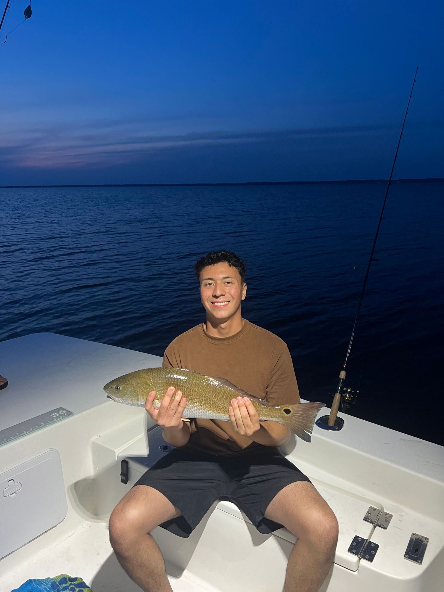 Night fishing success with impressive redfish catch displayed on boat deck.