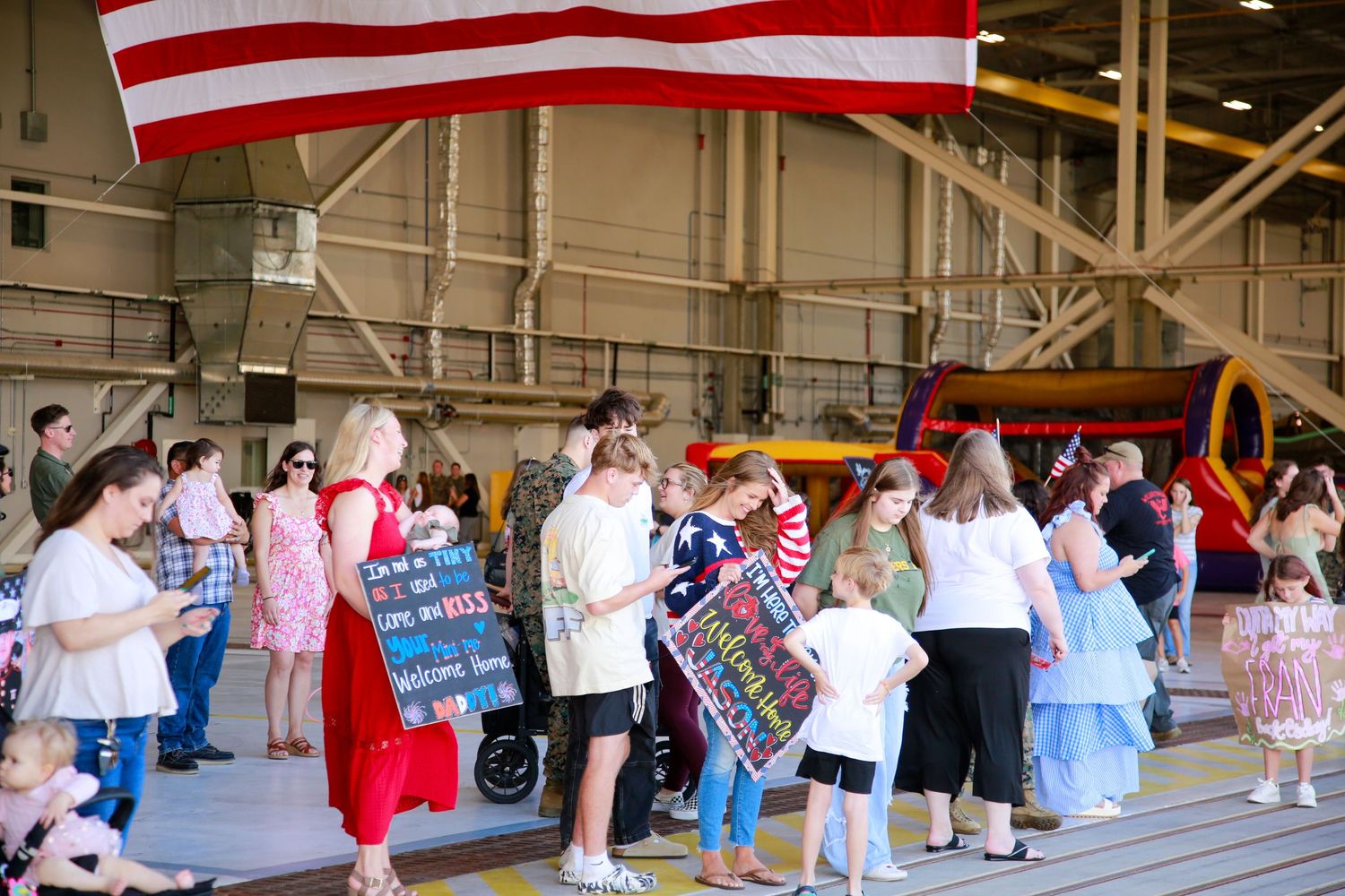 A line of people waiting outside a building with red and white decorations.