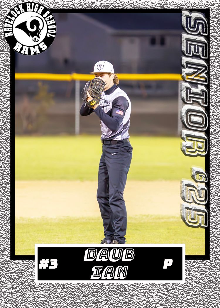 Baseball player in navy uniform stands ready in pitching position on field at night.