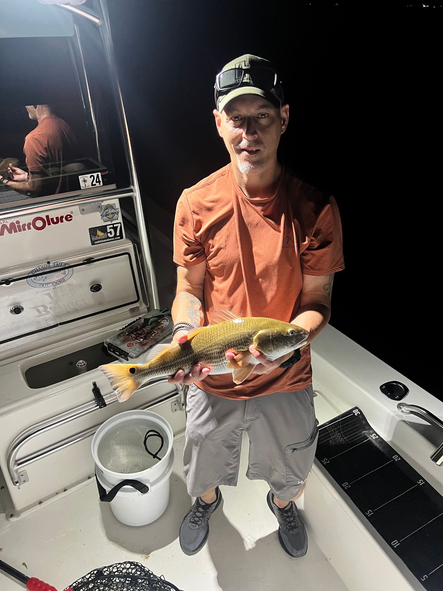 A series of photographs showing fishing catches of redfish being handled on a white boat deck.