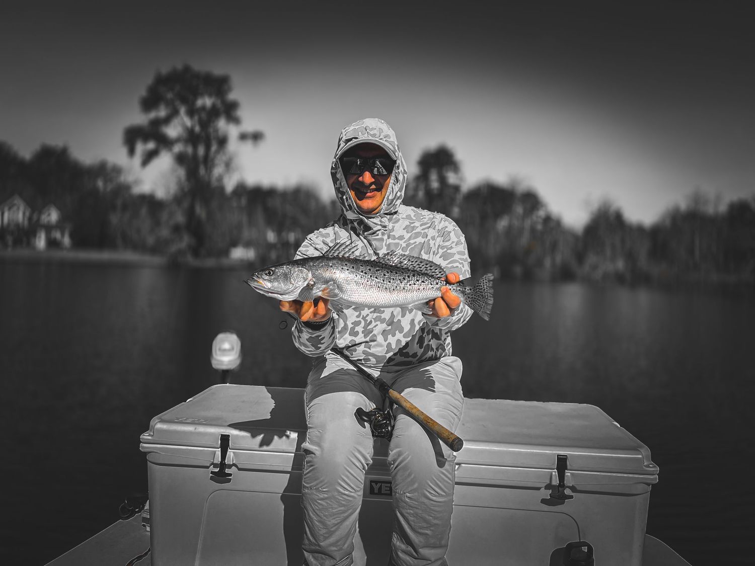 Black and white series of fishing photographs showing a boat trip on a calm lake.
