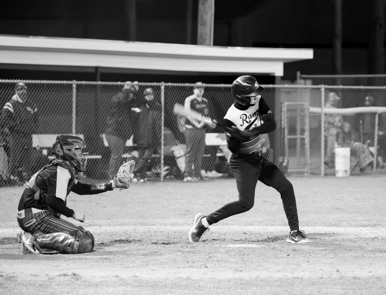 Baseball player at bat during intense game moment in black and white.
