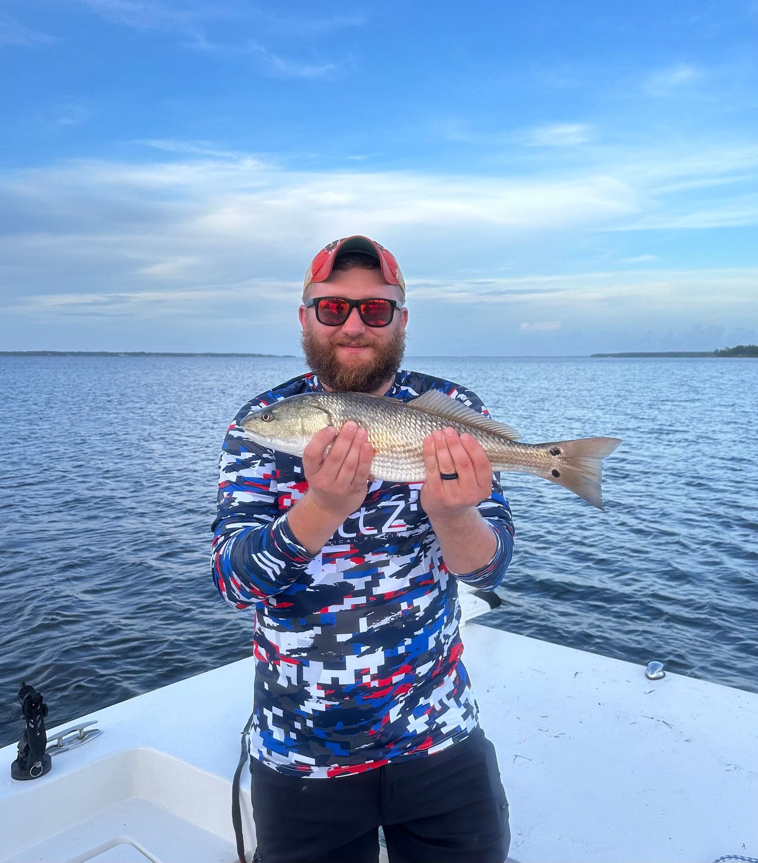 Fishing photos showing redfish catches in bright daylight conditions on a boat.