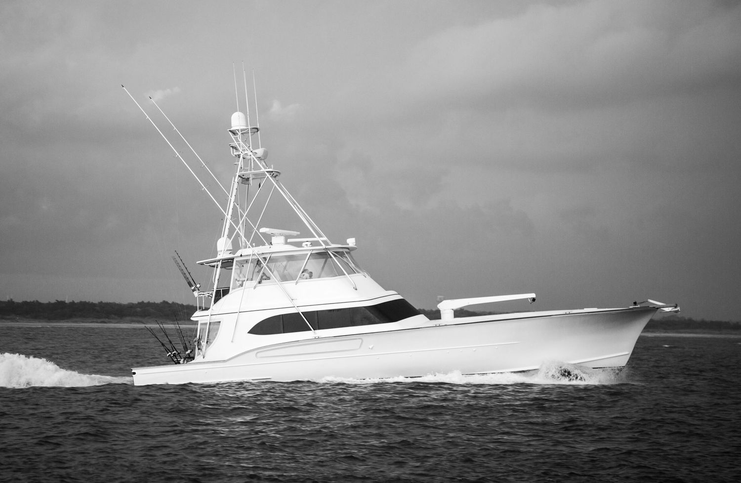 White sport fishing vessels cruising in formation across open water.