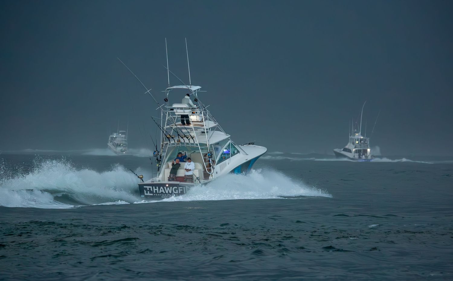 Multiple fishing vessels traverse choppy waters in offshore ocean conditions.