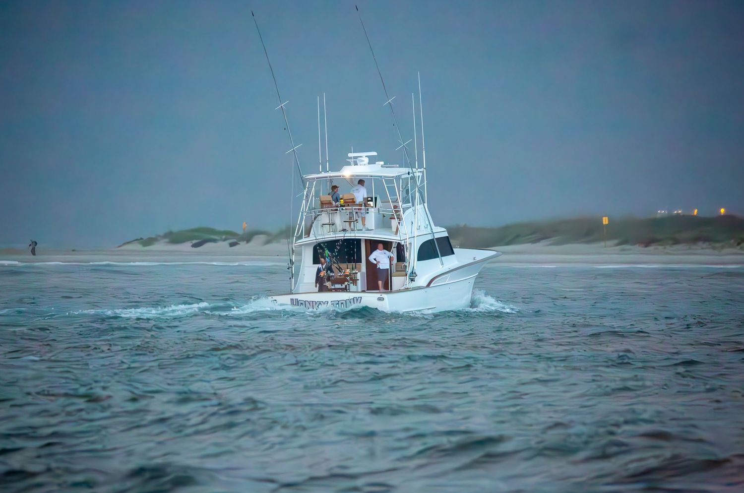 Sport fishing boats navigate through stormy seas near coastal waters.