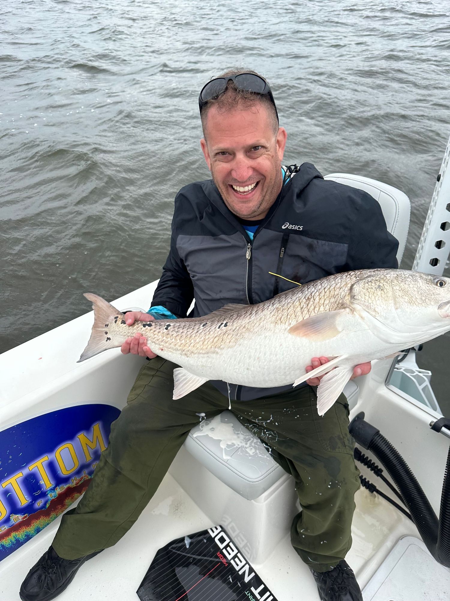 Multiple redfish catches displayed on a boat during an overcast day.