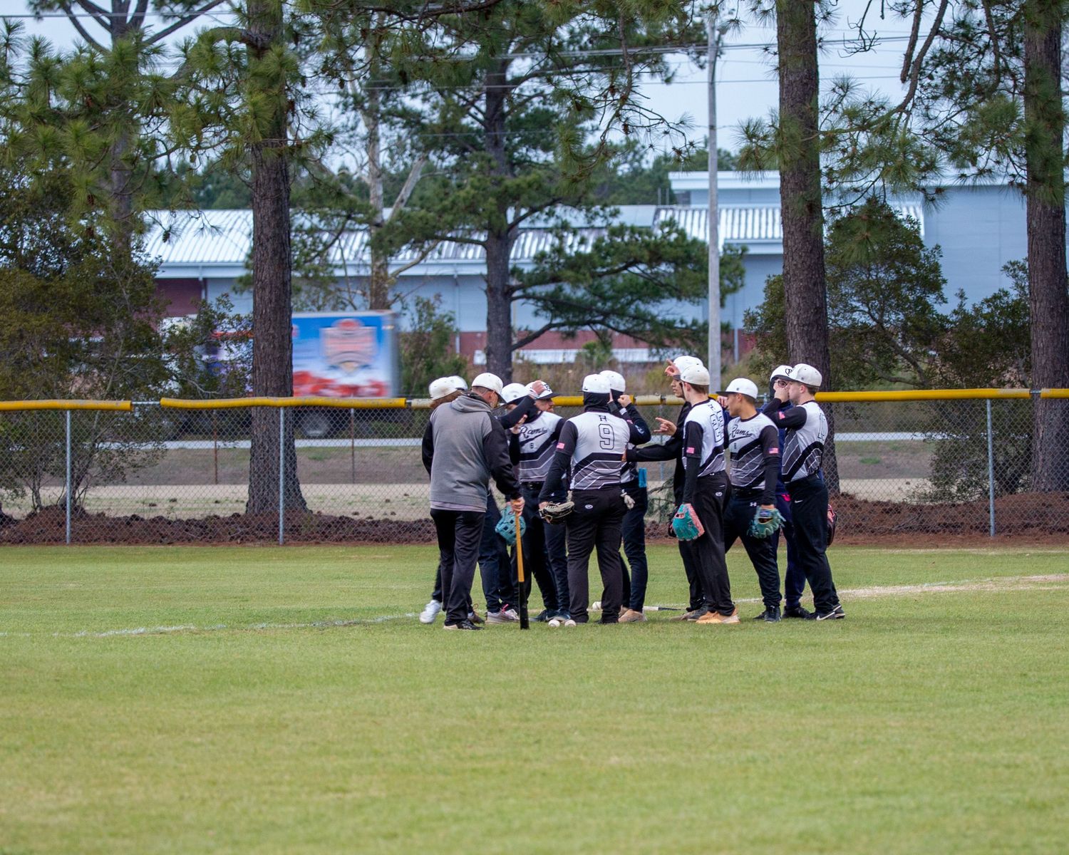 Baseball team huddled together on field following warm up session.