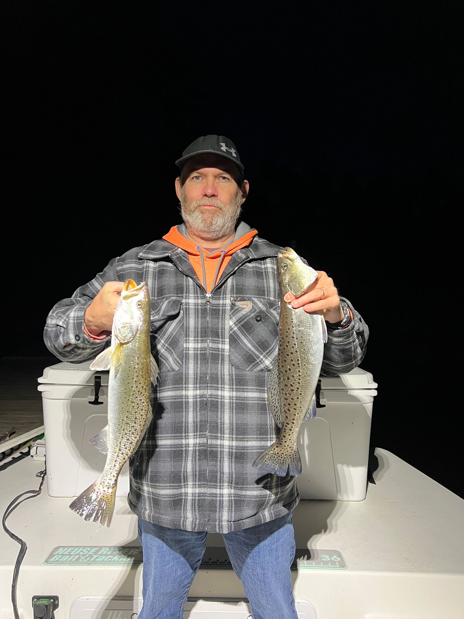 Multiple shots of caught crappie fish being displayed on a boat at night.