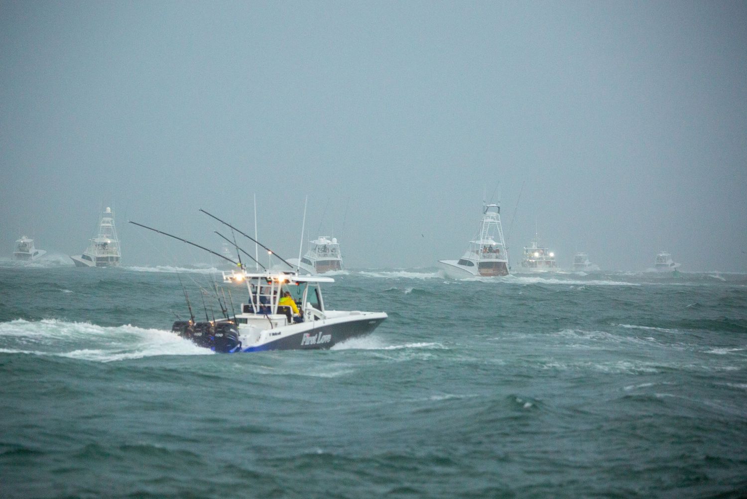 Fishing boats navigating through stormy seas with rough waves.