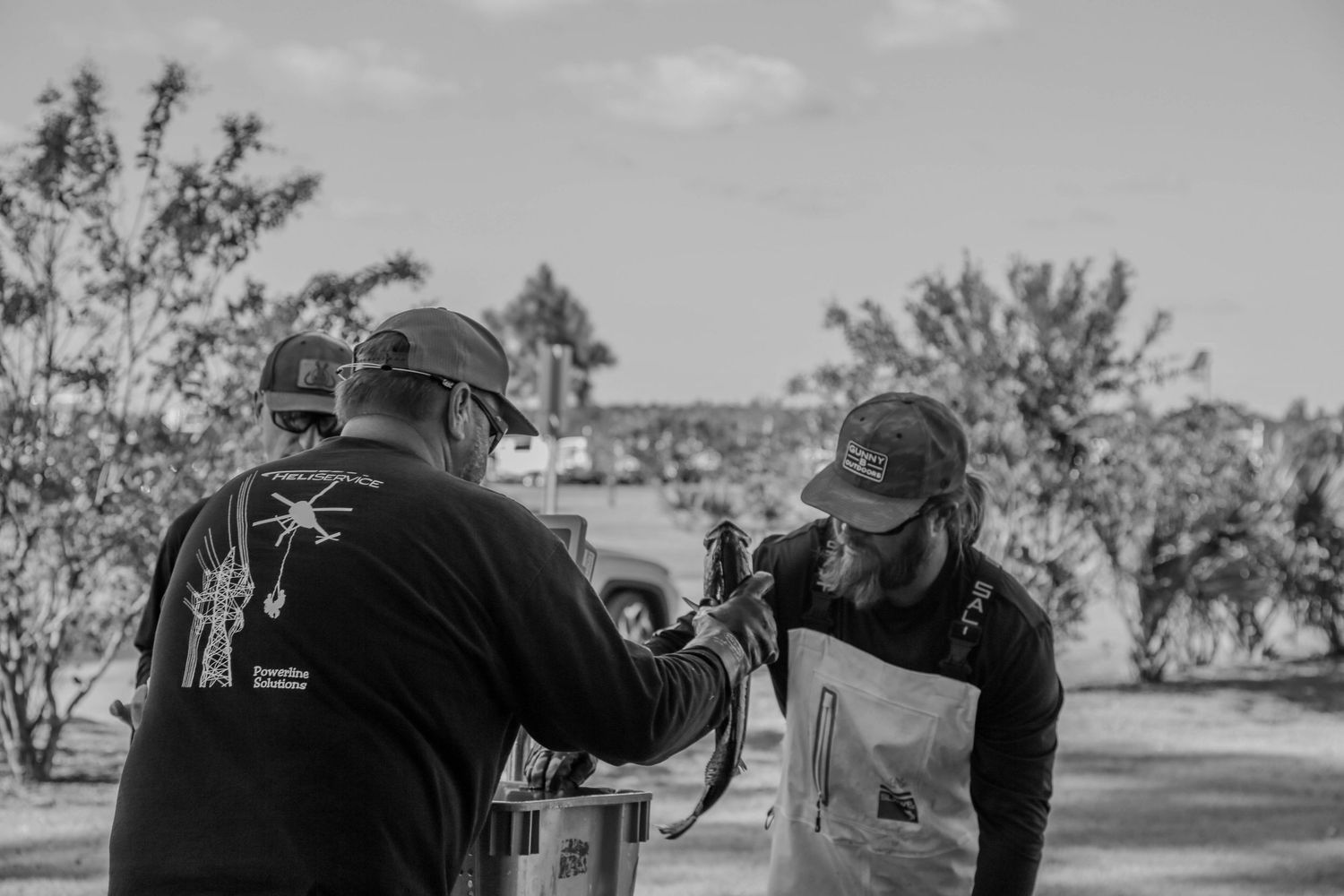Black and white photo of tournament officials processing catch weigh-in.