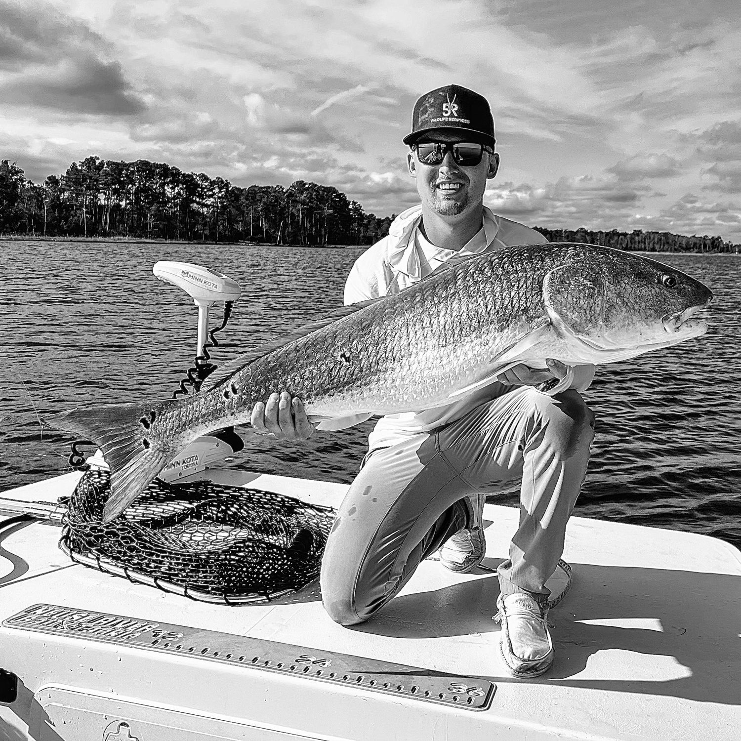 Black and white photos of impressive redfish catches displayed on a boat deck.