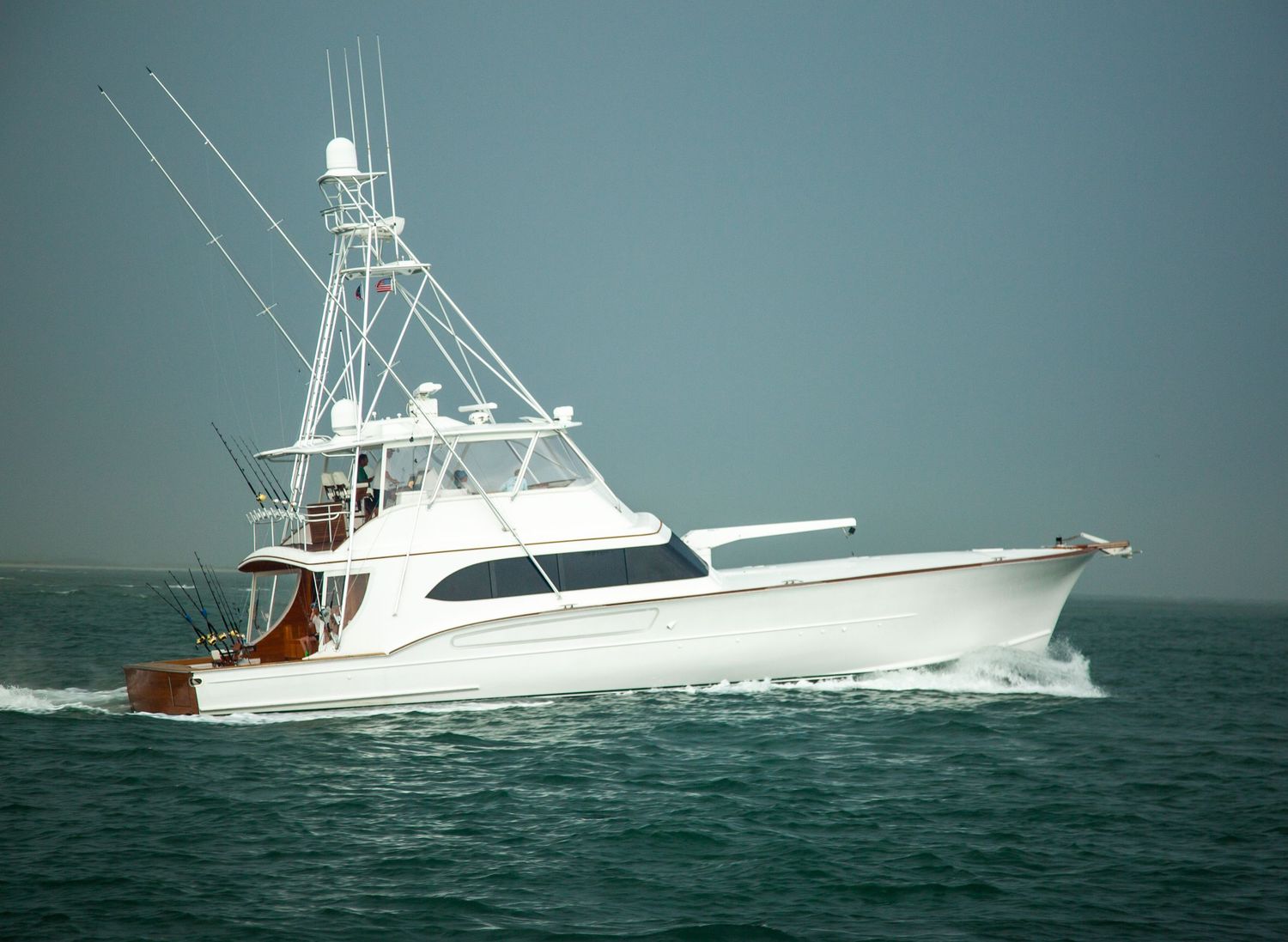 Large sport fishing vessels traveling in sequence through ocean waters.