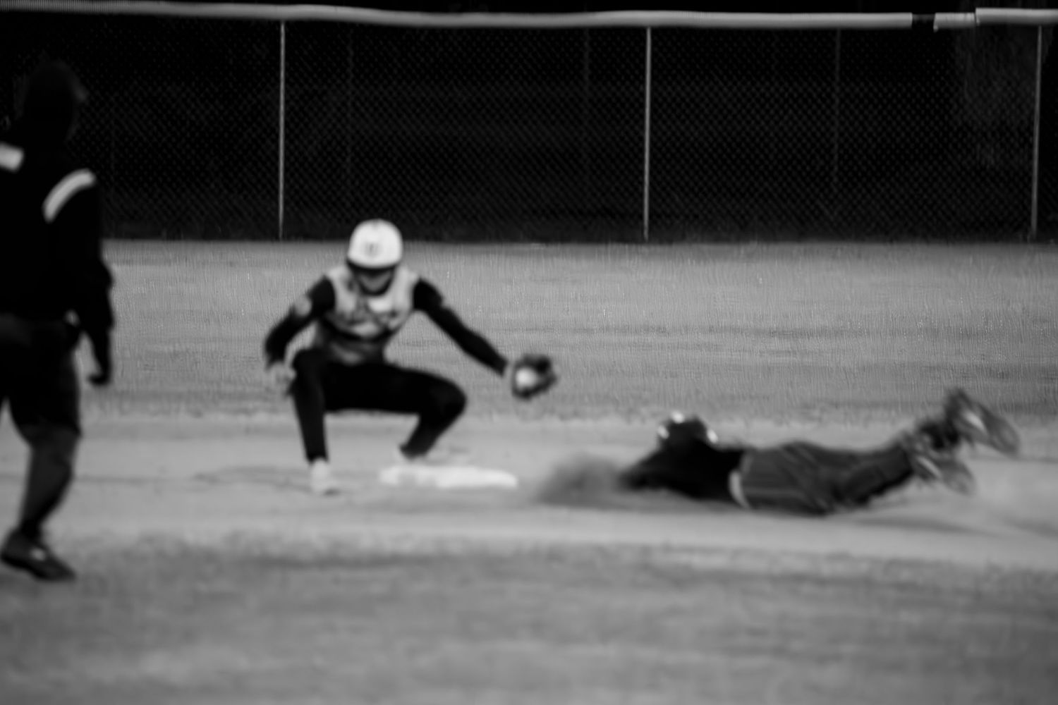 Baseball player sliding into 2nd base during game.