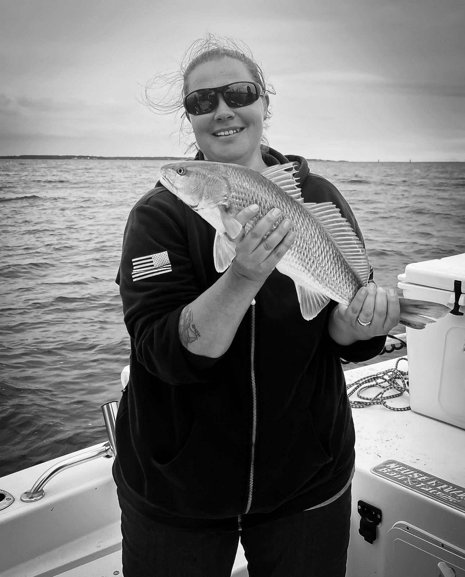Black and white photos of redfish catches displayed on a boat deck.