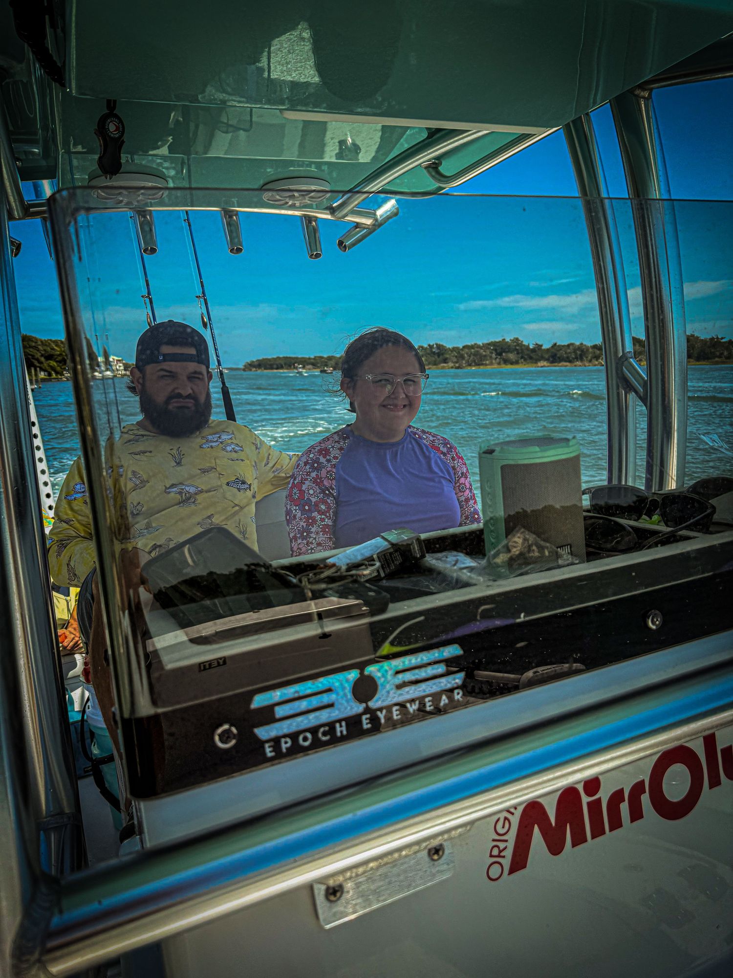 View through the window of a food service vehicle showing interior with bright blue sky and beach scenery visible in background.