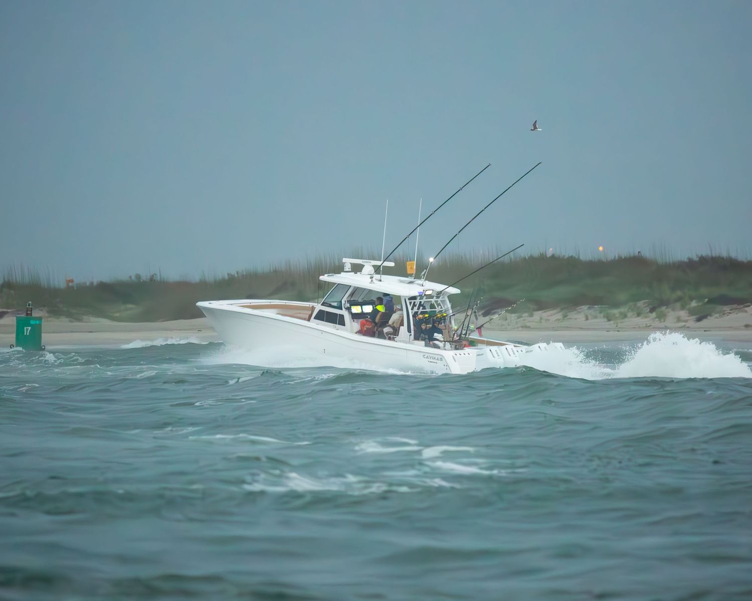 Sport fishing boats cruise through choppy coastal waters on overcast day.