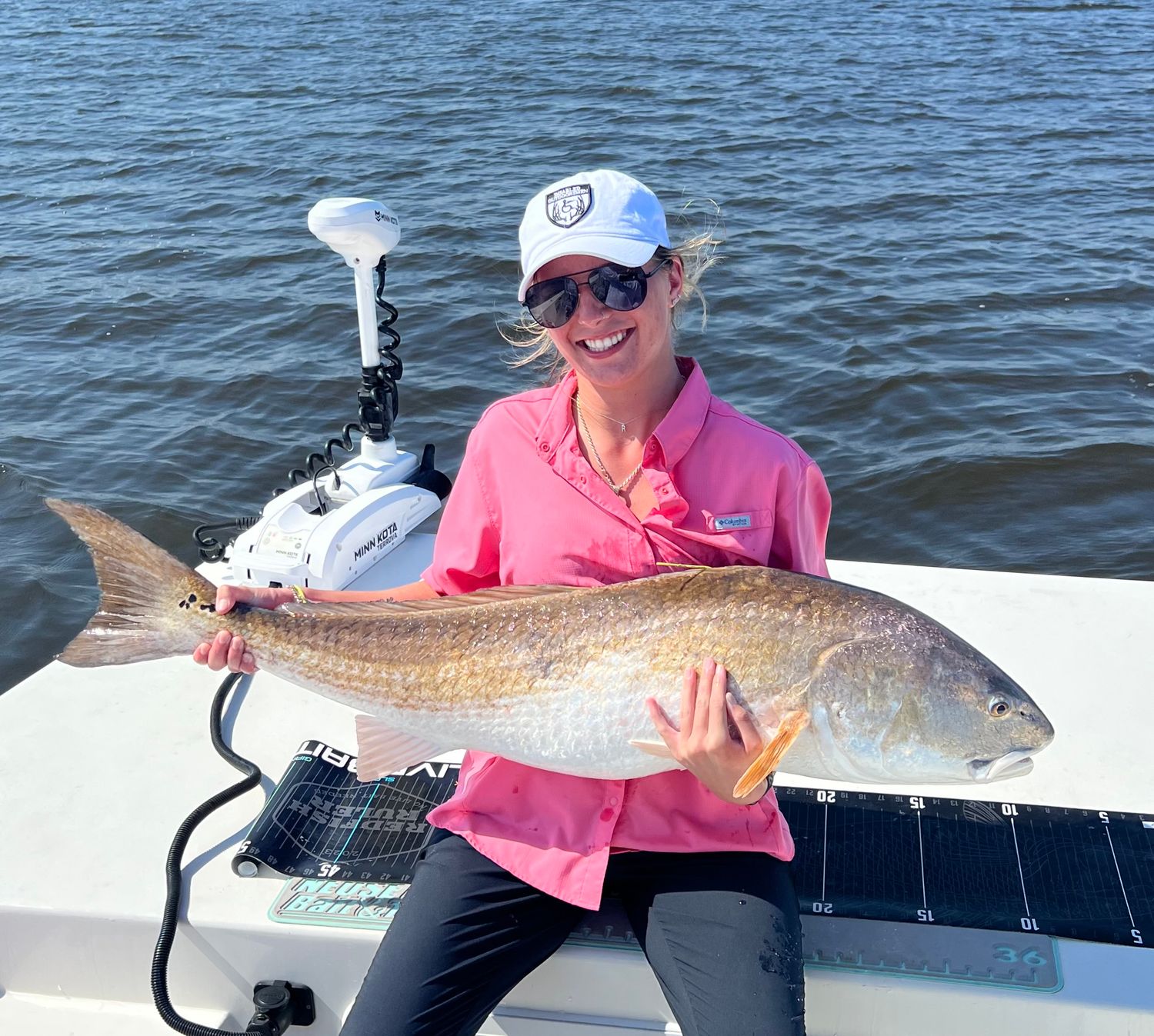 Series of successful redfish catches displayed on a white fishing boat deck.