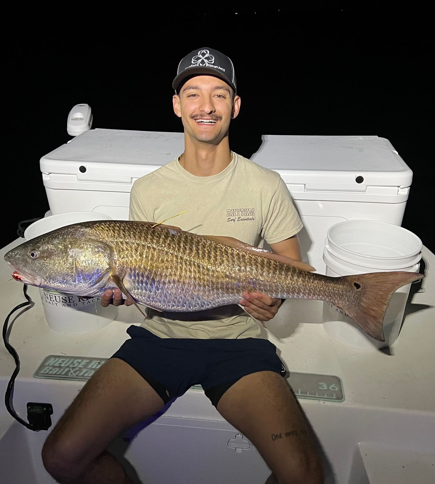 Impressive redfish catch displayed on a white boat deck during nighttime fishing.