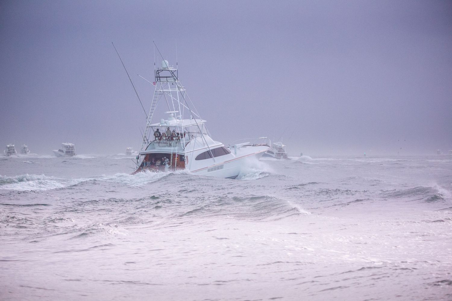 Sport fishing vessel battles through massive storm waves in harsh weather conditions.