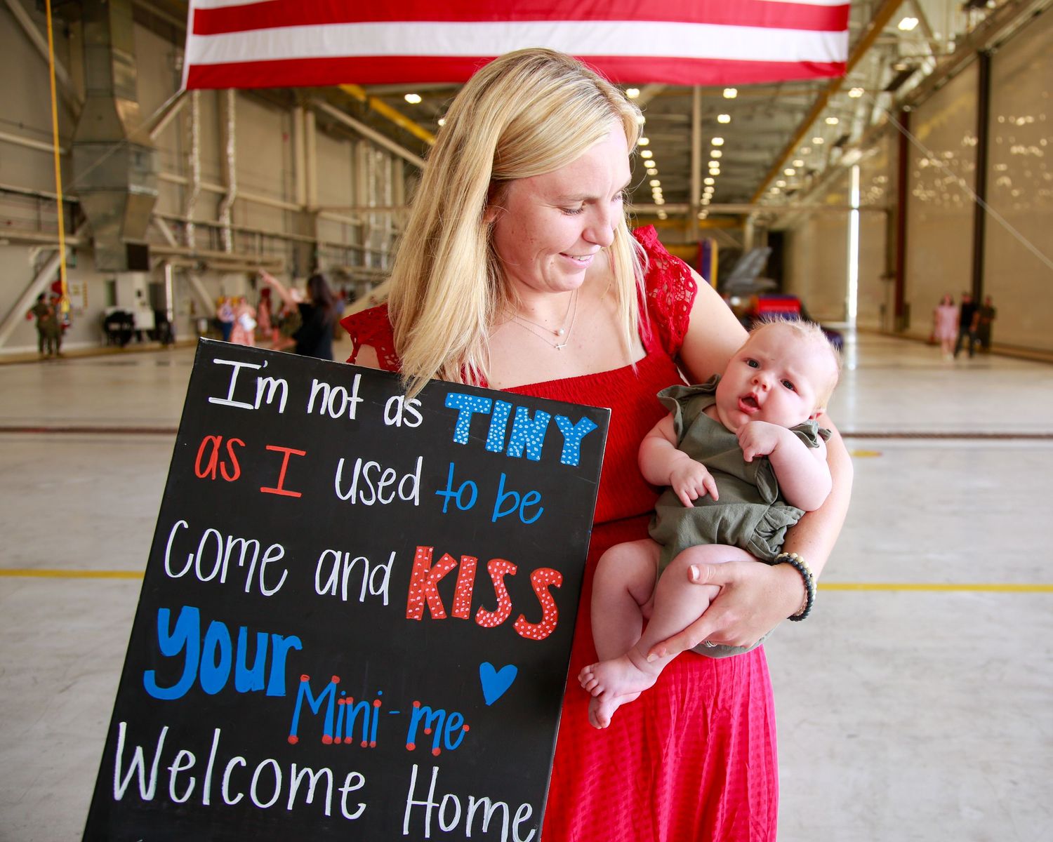 A collage of welcome home signs and decorations in red white and blue with American flags displayed.