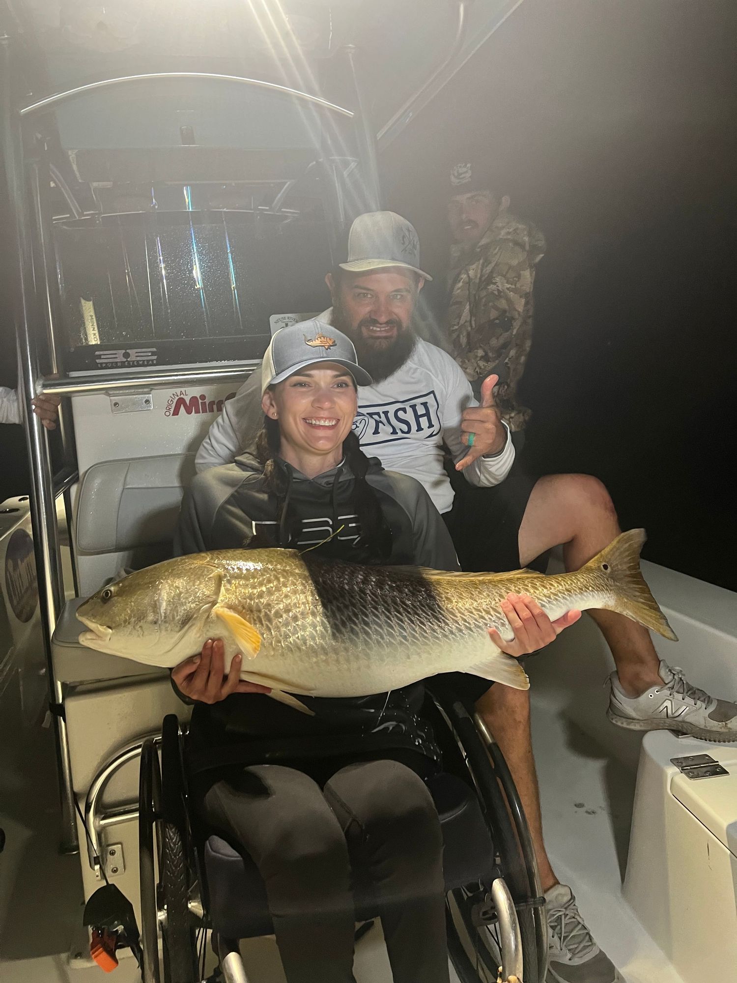 Successful fishing trip with large redfish catch displayed on a boat at night.
