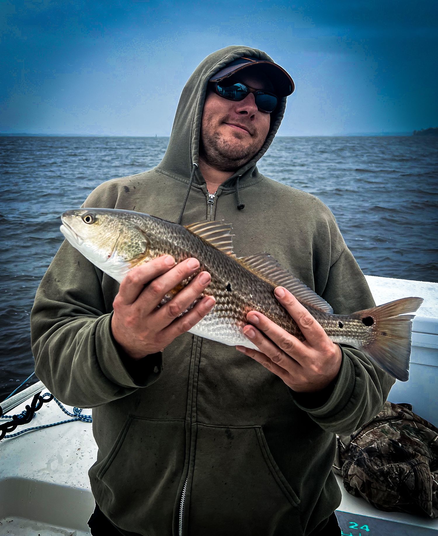 Multiple shots of caught redfish displayed against blue ocean background.