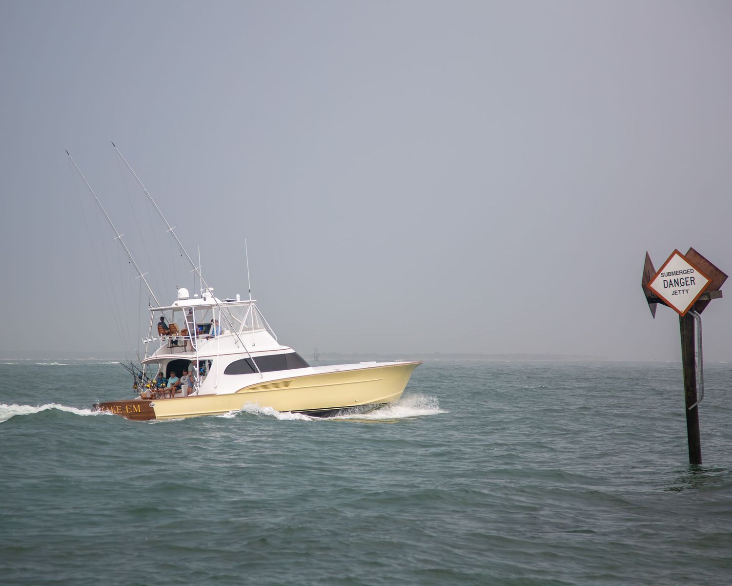 Sportfishing vessel passing a channel marker while navigating through rough seas.