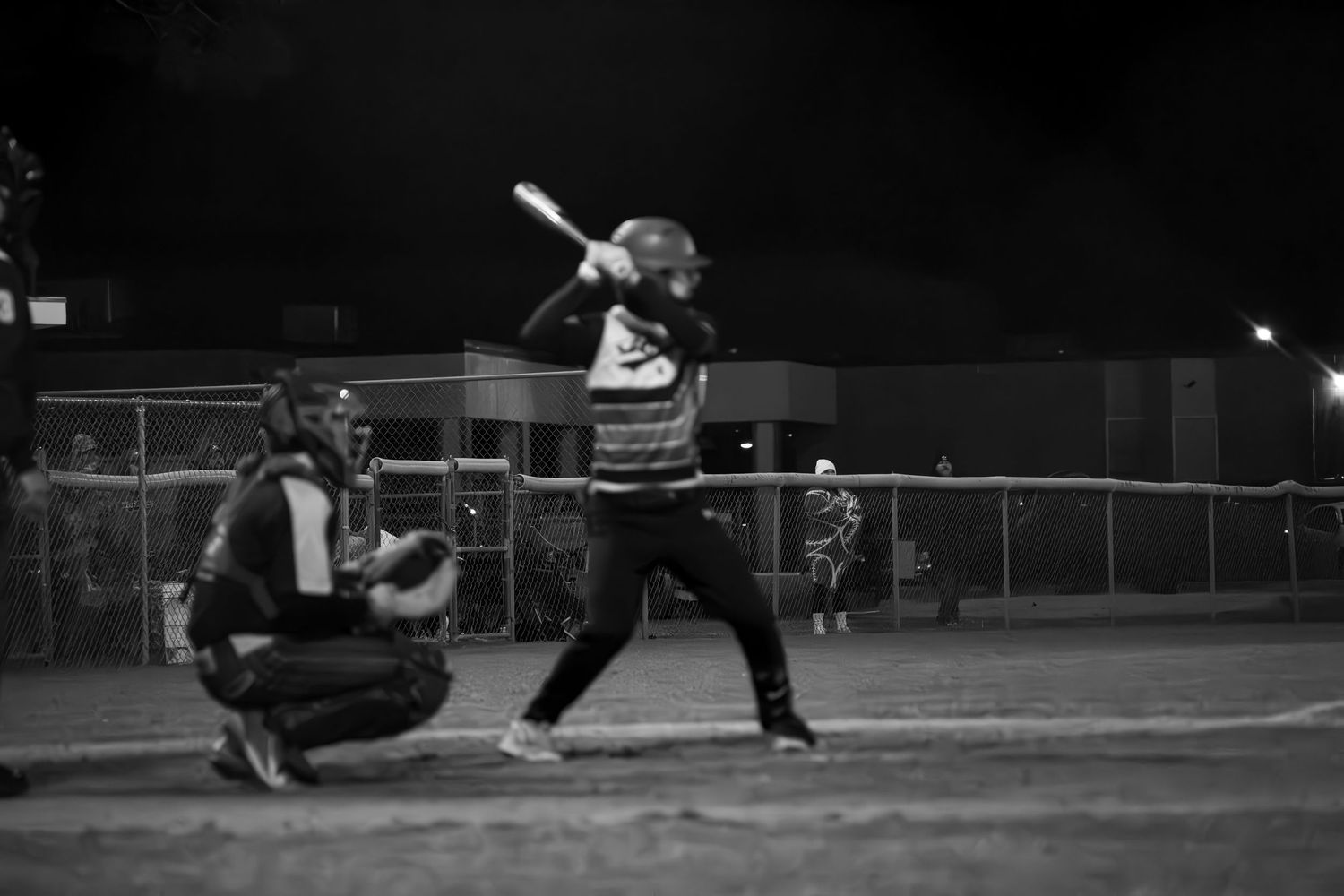 Baseball player batting in dramatic black and white photography.