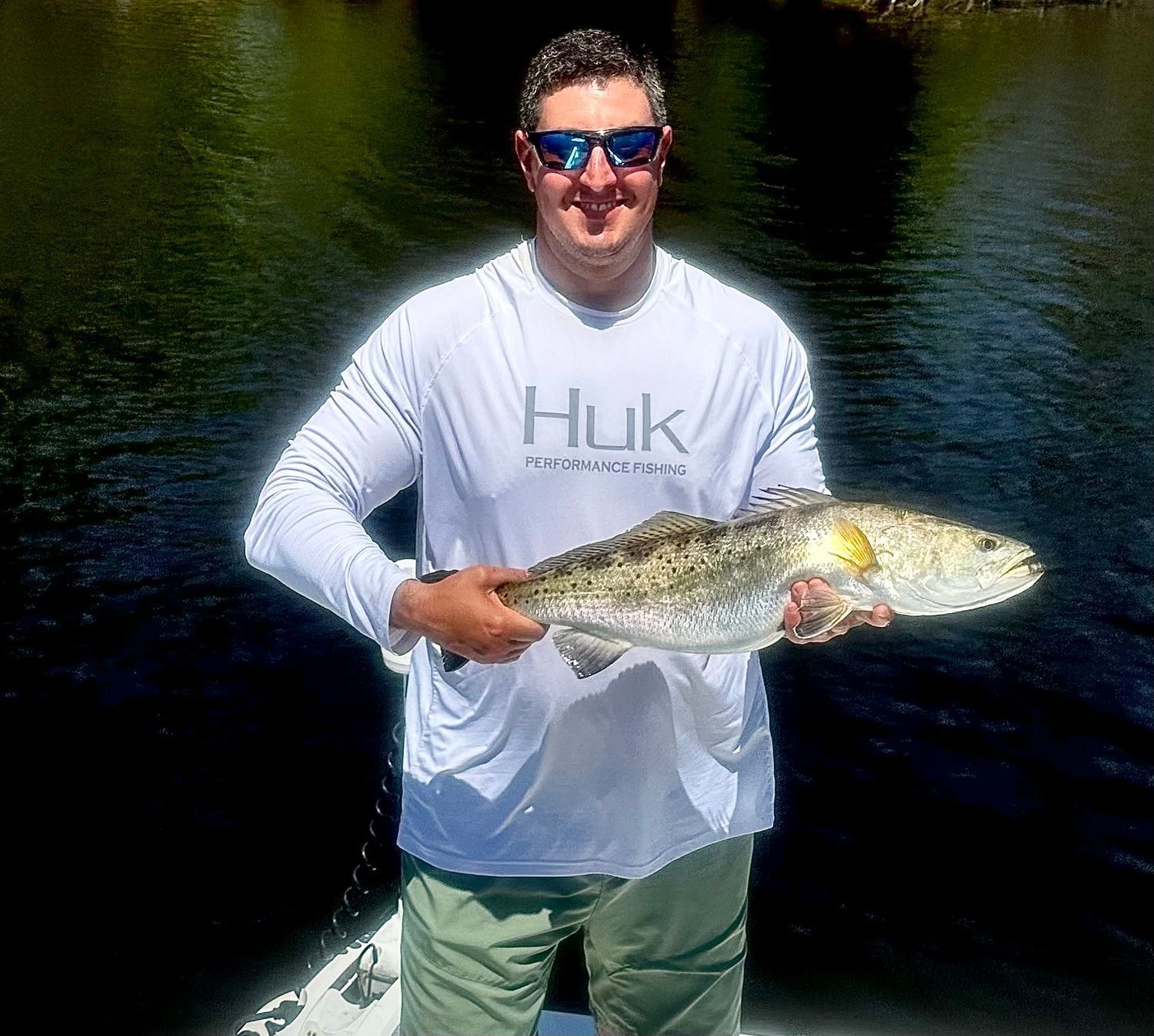 Anglers displaying their impressive catches of fish while out on sunny waters.