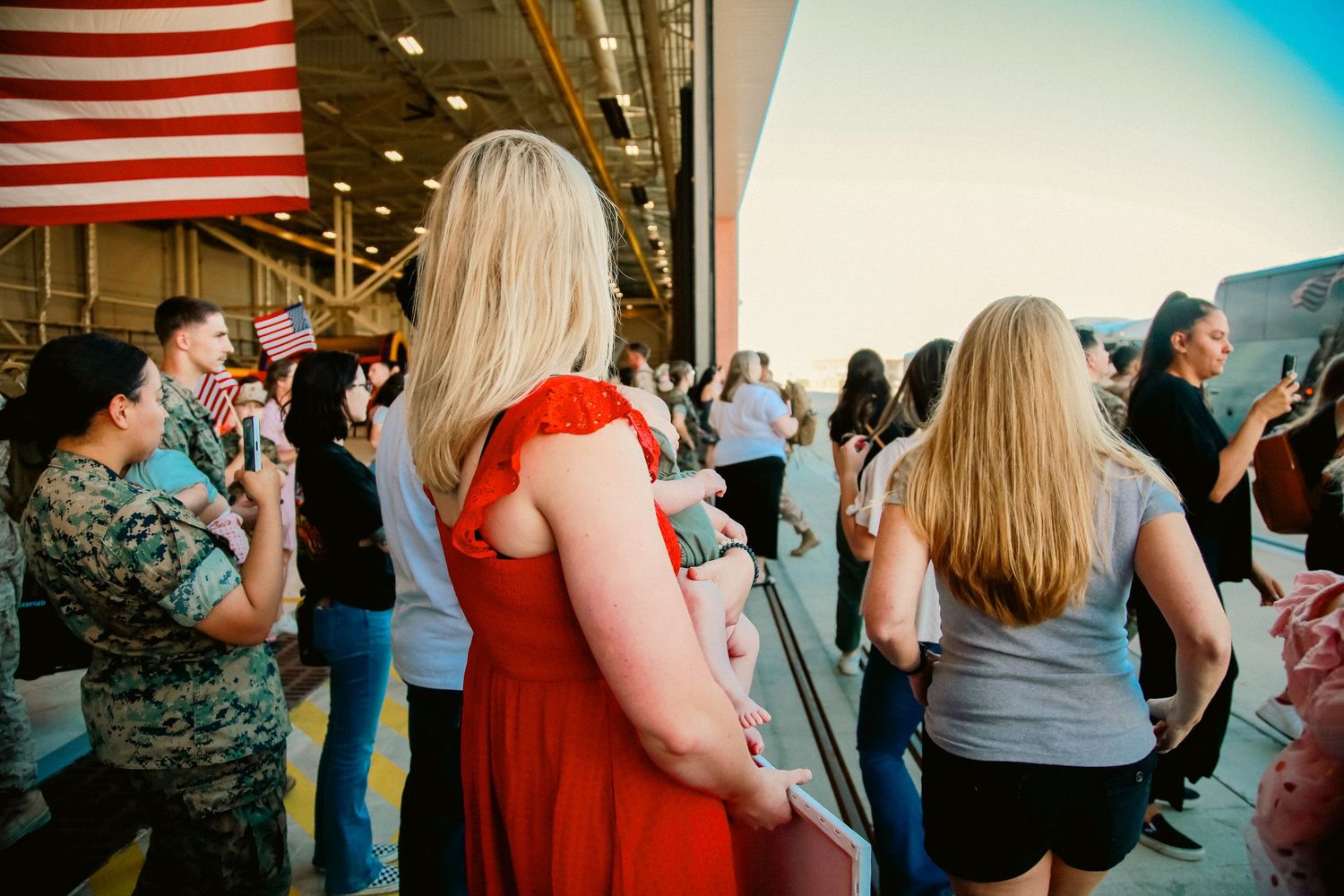Guests dancing and socializing at a wedding reception with American flags visible in the background.