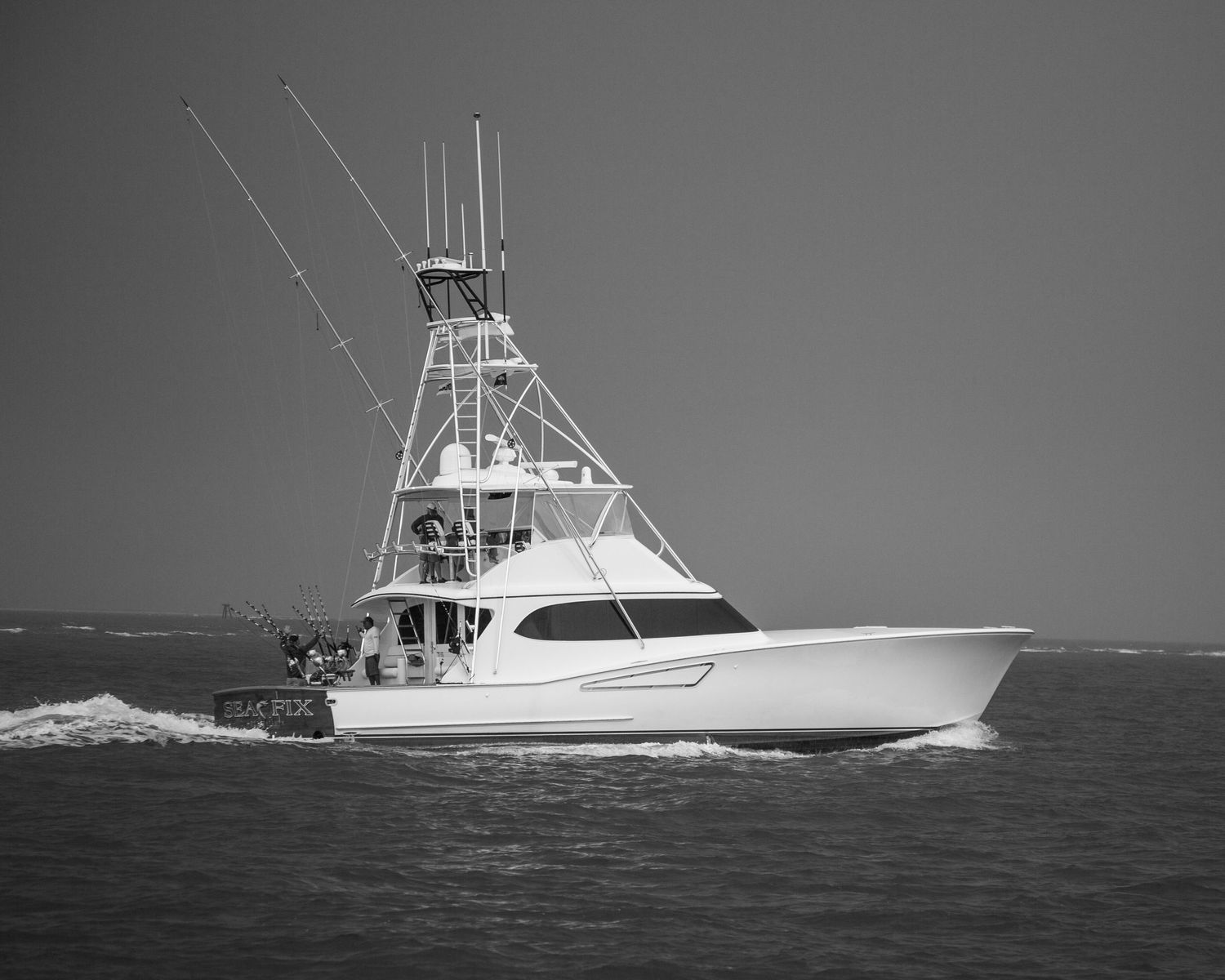 Elegant white sportfishing boat photographed against dark moody skies.