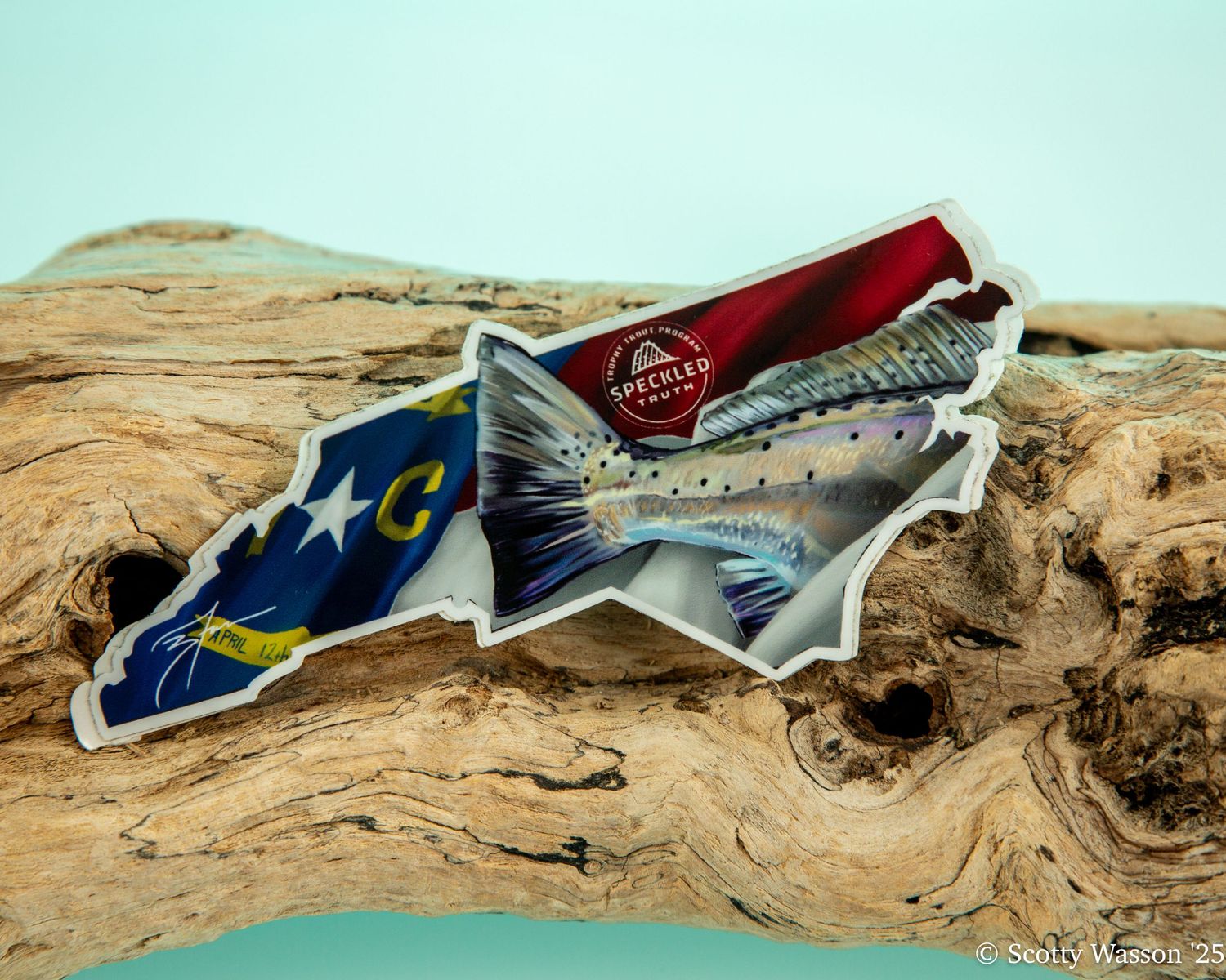 North Carolina state shaped sticker featuring a trout fish and state flag design on driftwood.