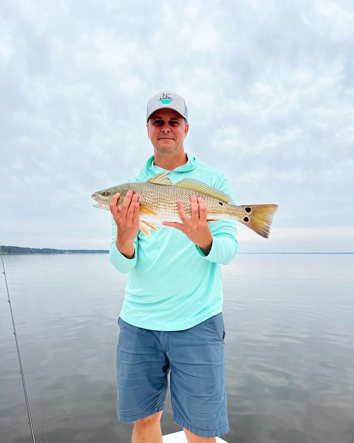Fishing success shown with multiple redfish catches displayed on boat deck in coastal waters.