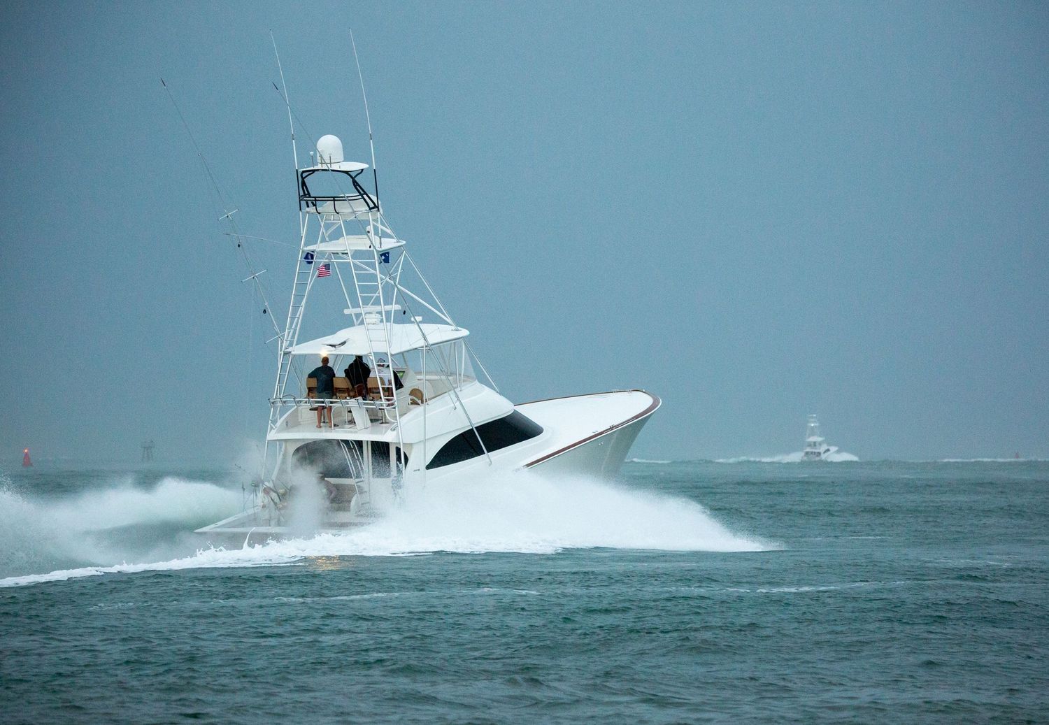 Sport fishing vessels racing through turbulent ocean waters with white spray.