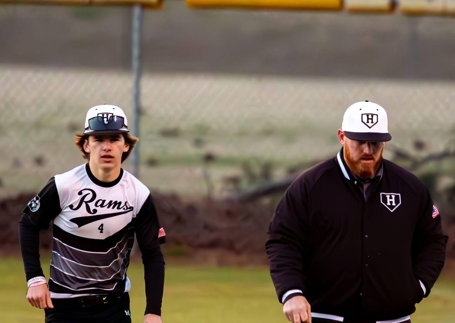 Baseball team members wearing uniform caps and jerseys during warm ups.
