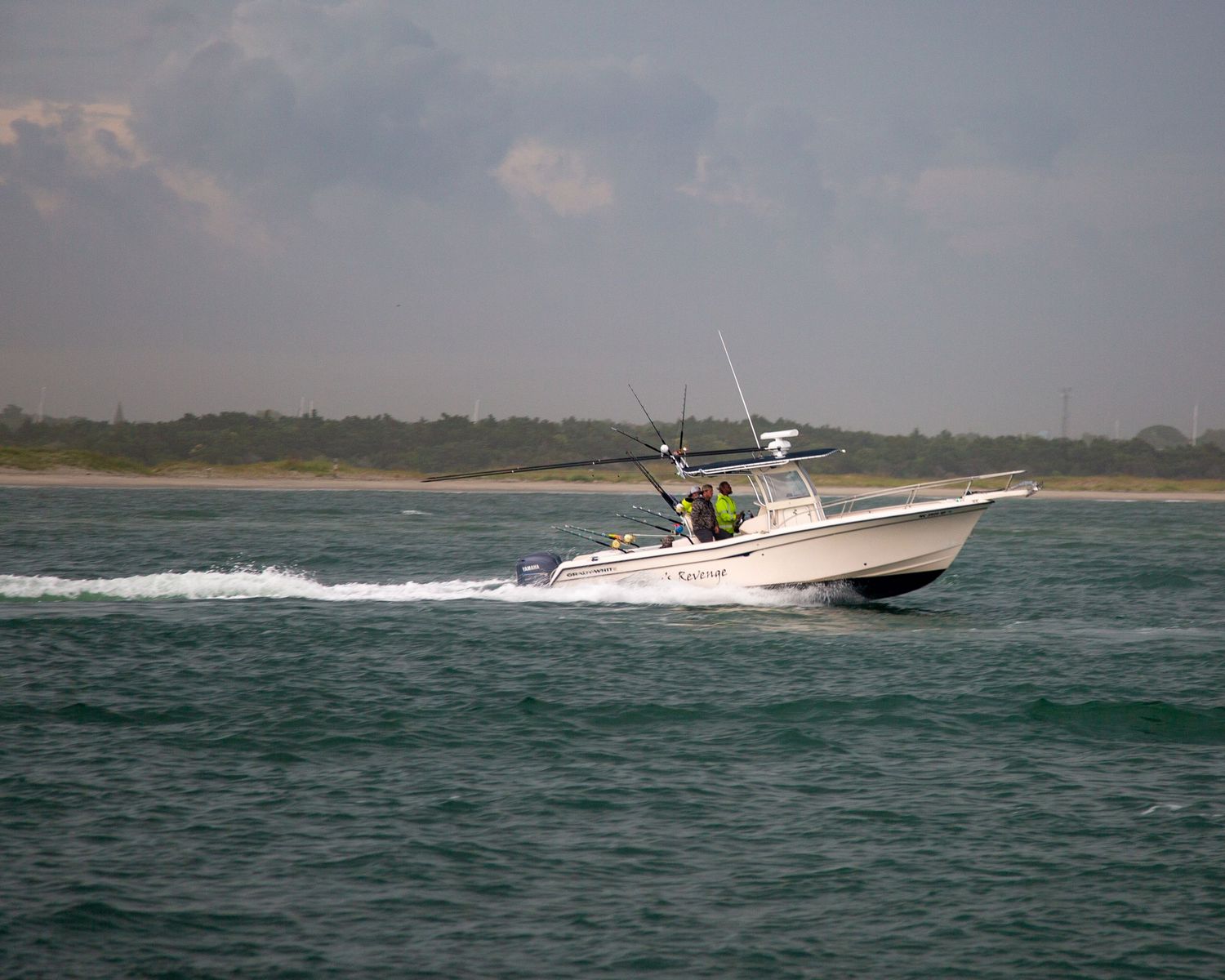 Sport fishing vessels racing across calm coastal waters near the shoreline.