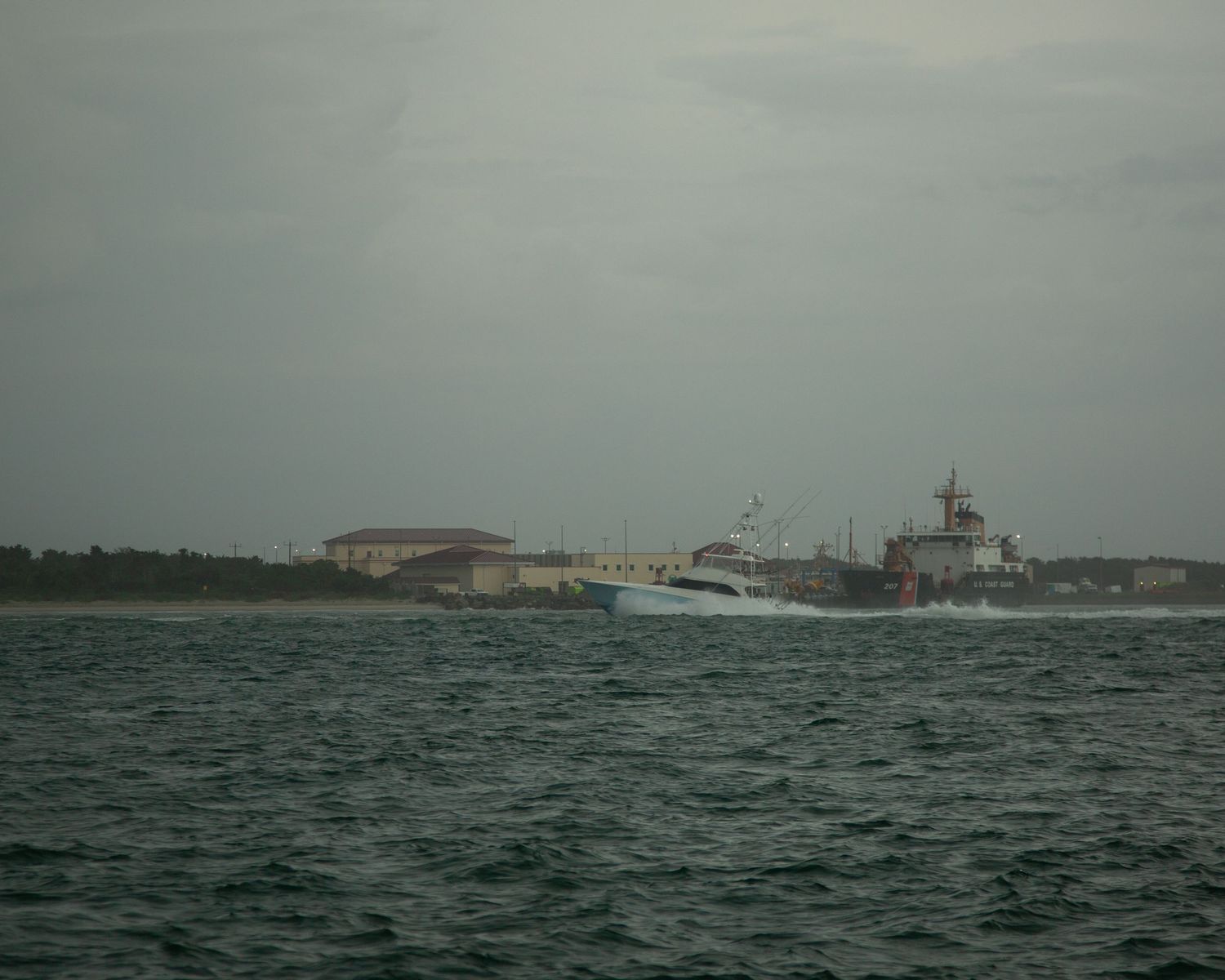 Distant view of coastal buildings and waterfront on an overcast day.