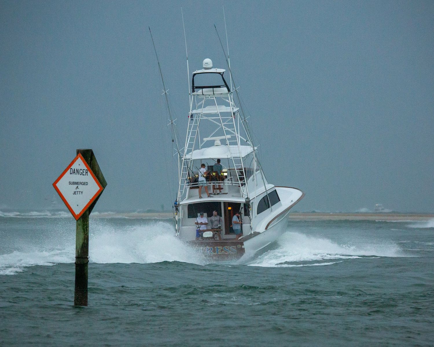 Charter boats pass navigation markers while cruising through rough waters.