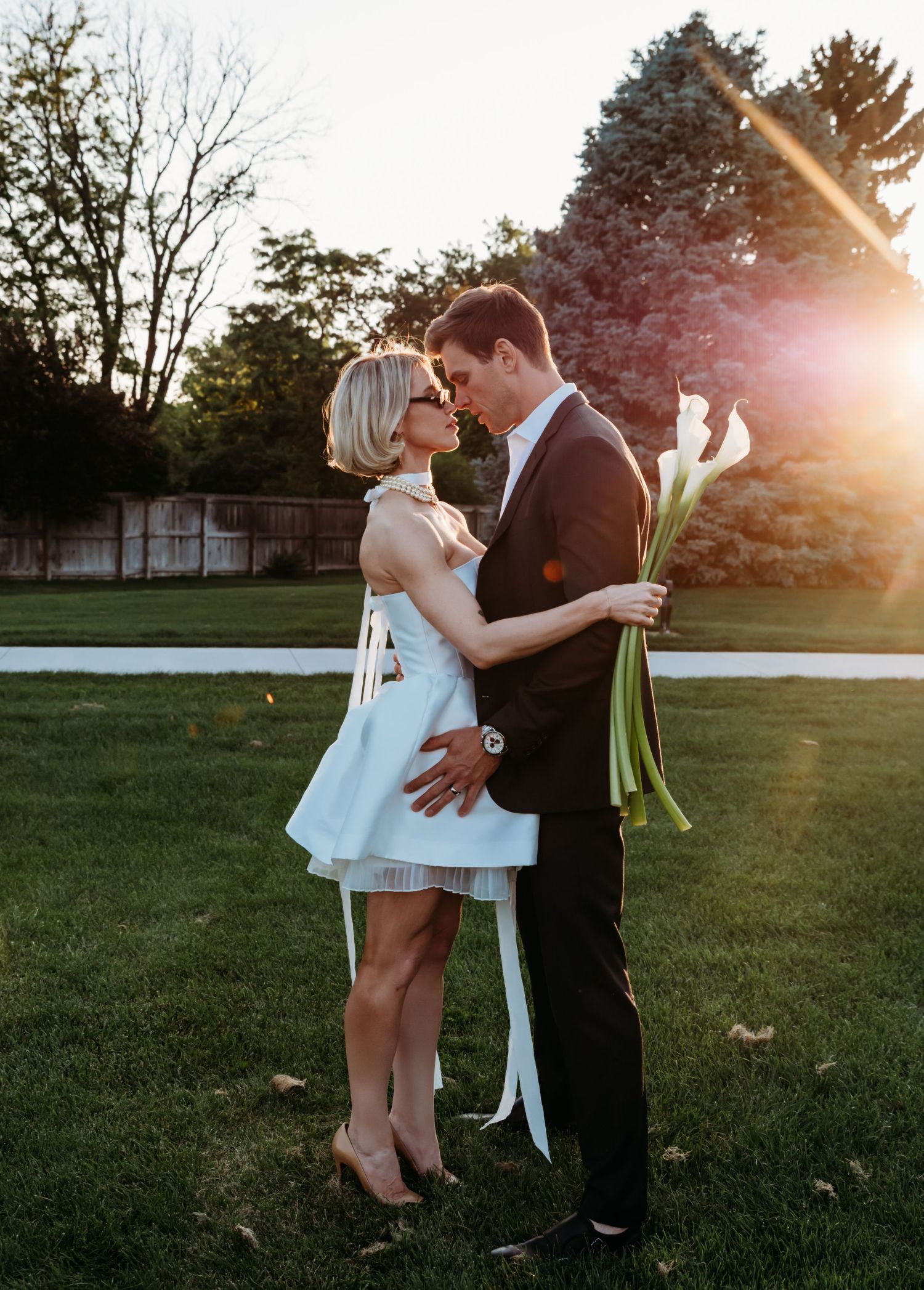 A couple shares intimate moments during a sunset photo session in a park, captured in a 5-panel sequence.