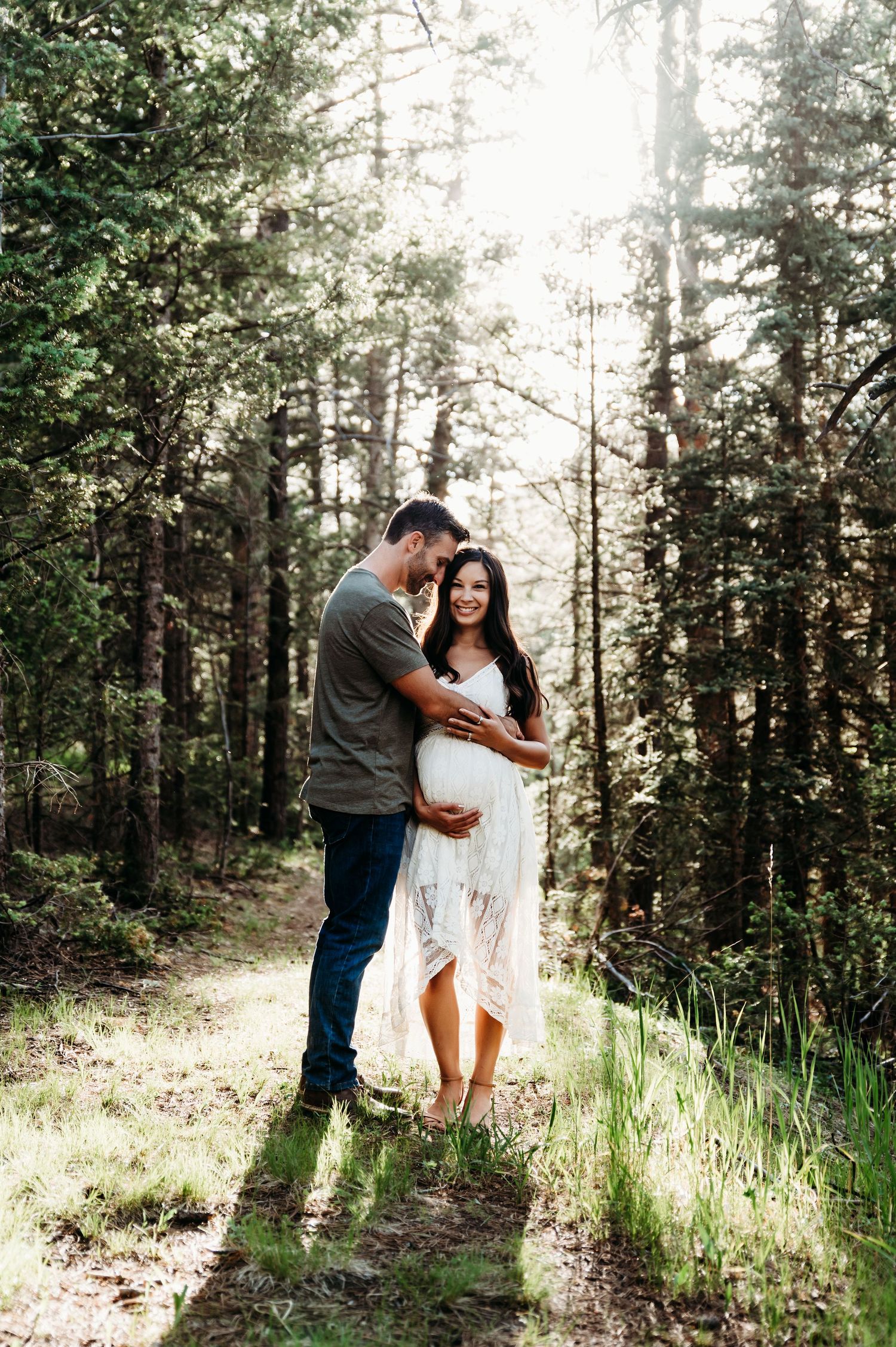 A romantic moment between a couple in a sunlit forest.