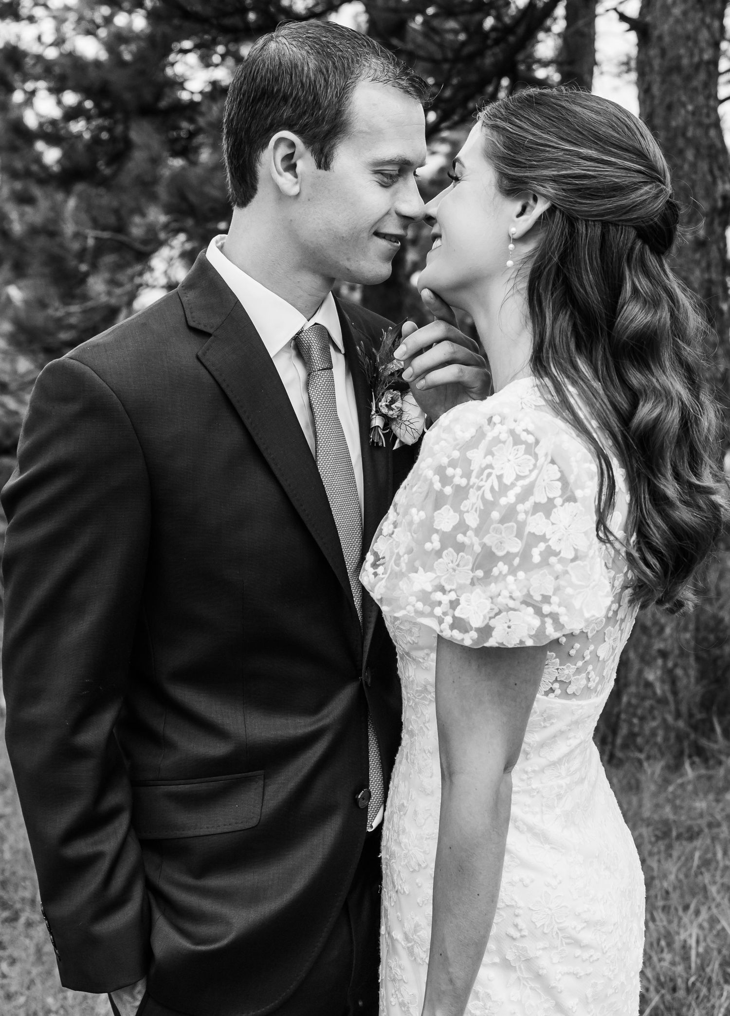 An intimate black and white portrait of newlyweds sharing a tender moment.