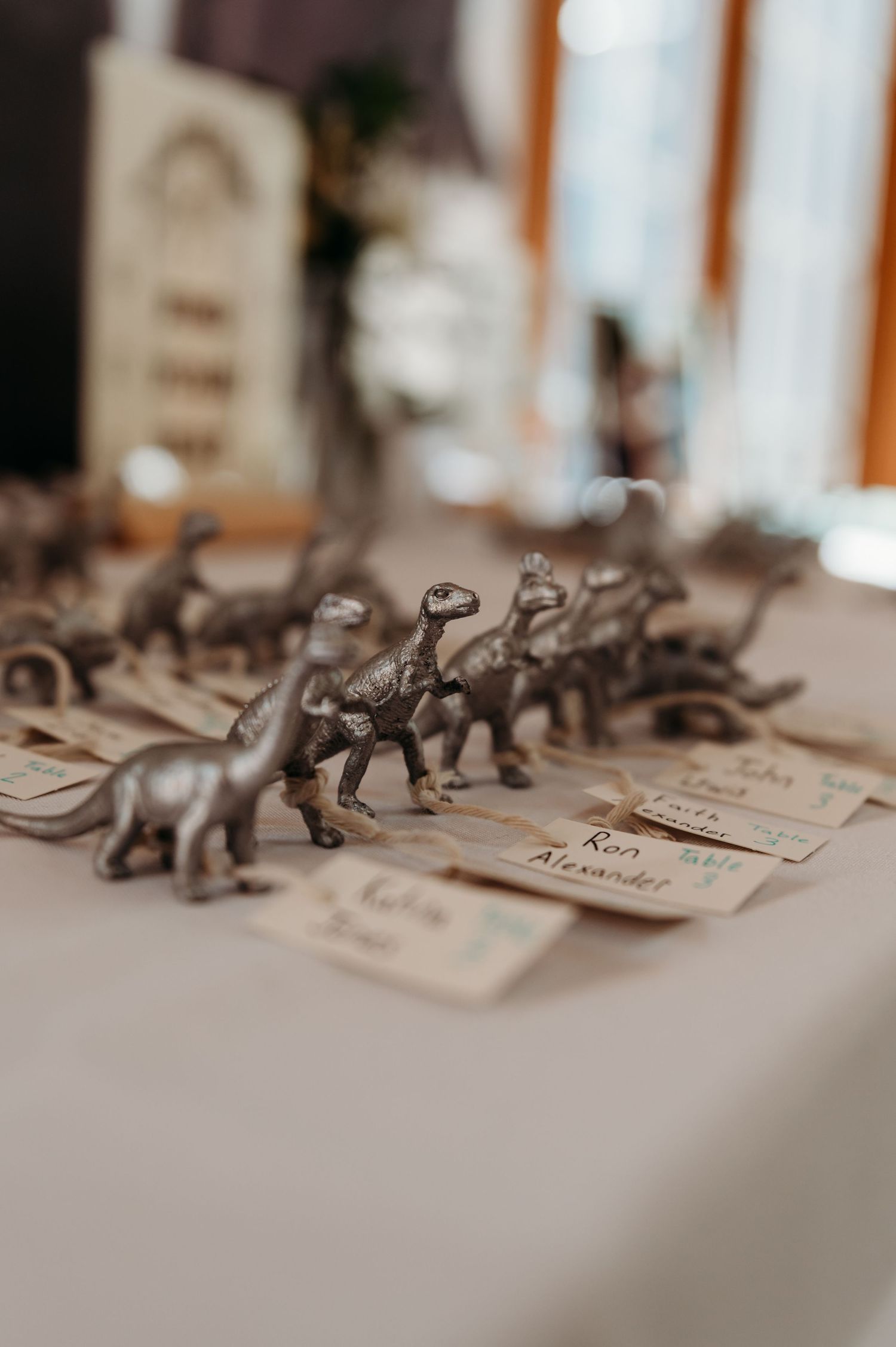 Small metallic elephant figurines arranged in a line on place cards for an elegant table setting.