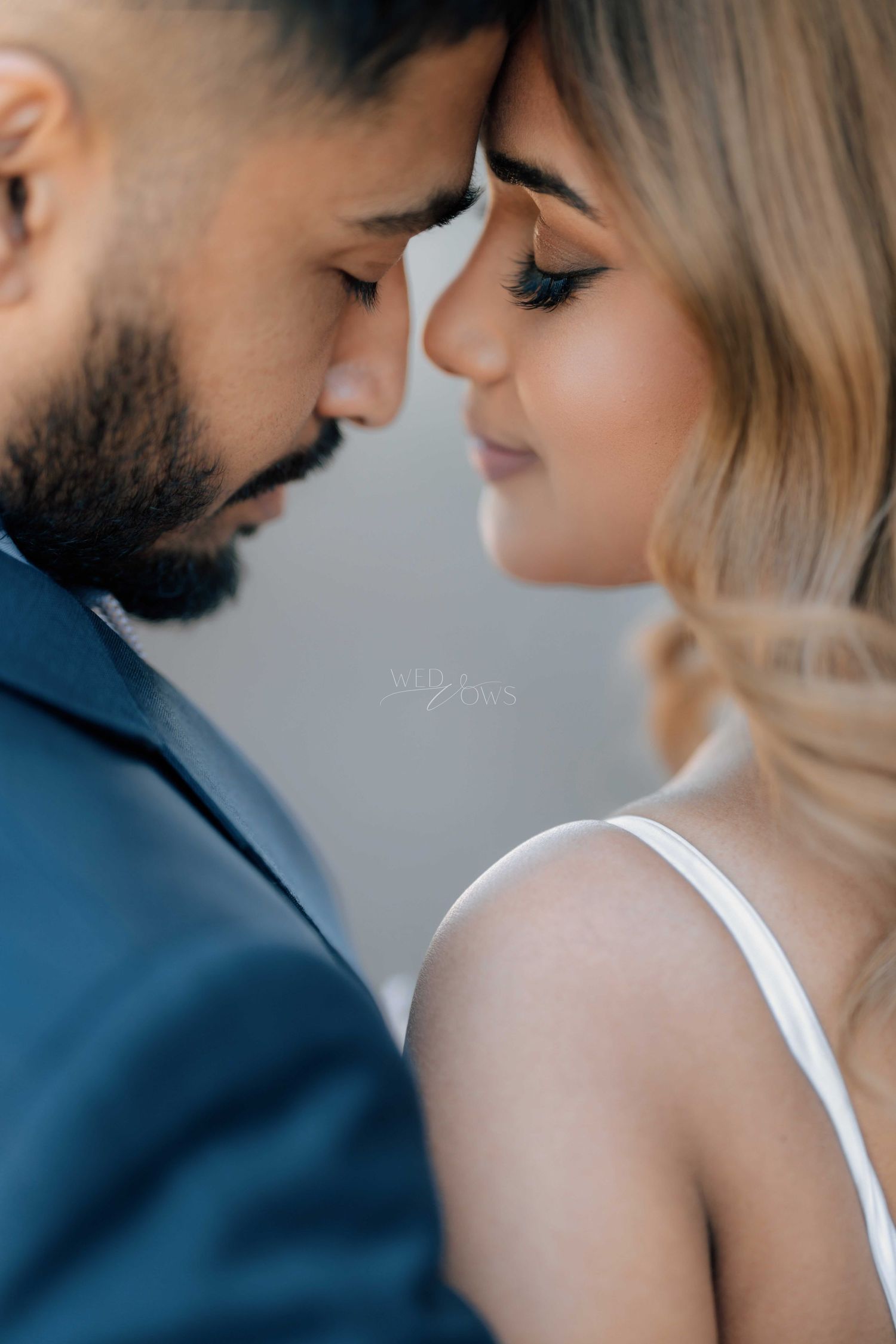 Intimate close-up of bride and groom touching foreheads tenderly on their wedding day.