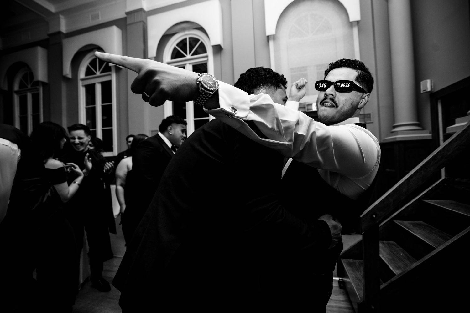 Black and white photo of a guest dancing exuberantly on the wedding reception dance floor.