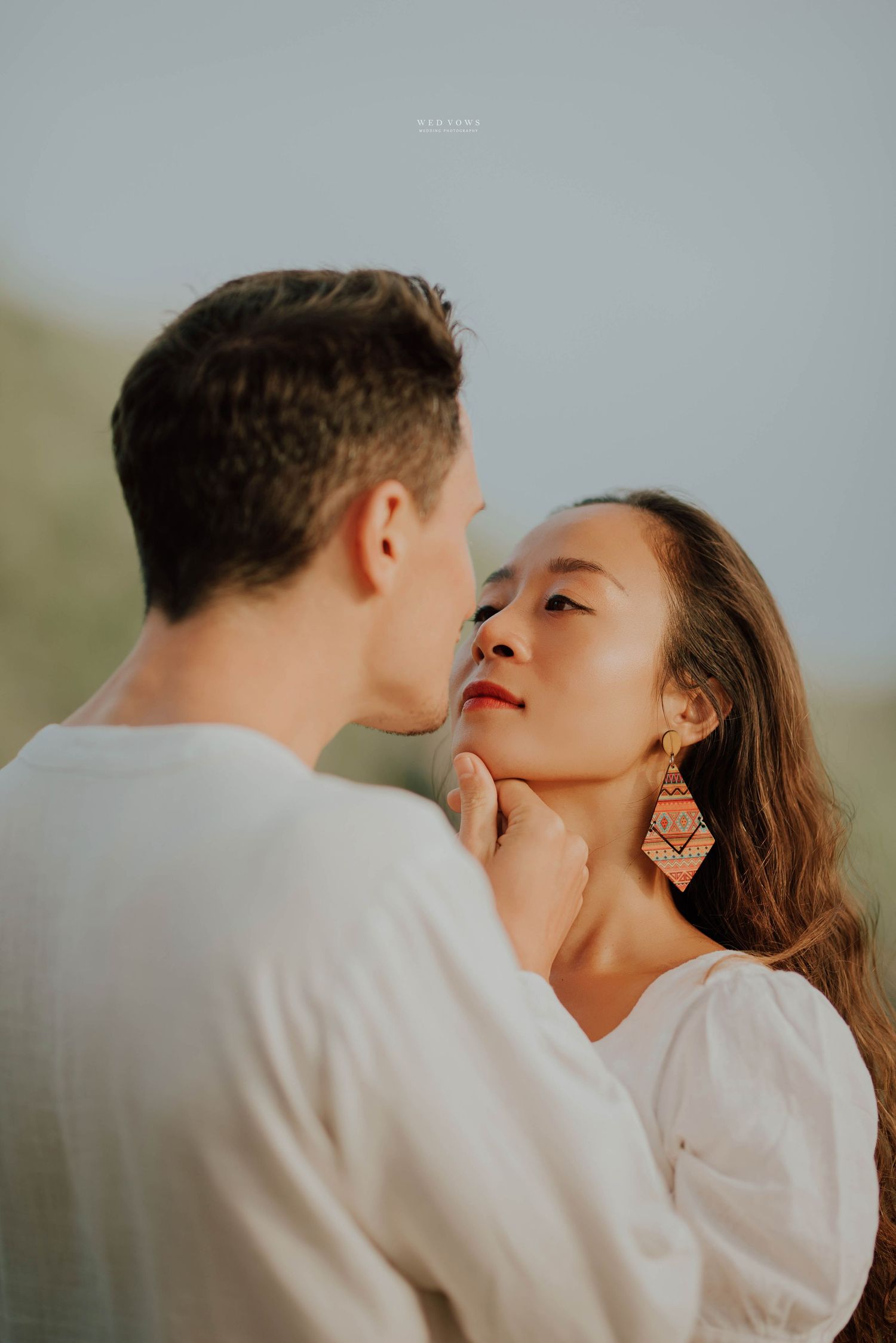 Couple sharing an intimate romantic moment with man gently holding womans chin.
