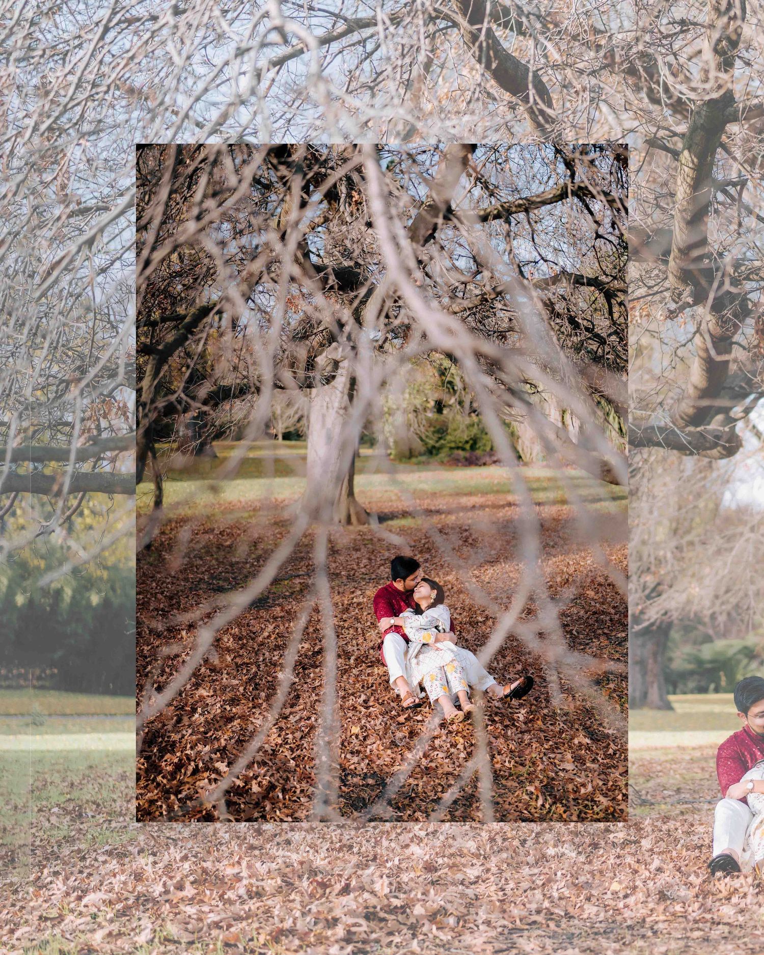 Couple in traditional Indian attire sharing a romantic moment seated among fallen autumn leaves in a park.