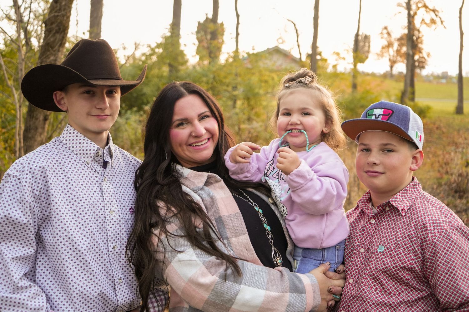 Family portrait outdoors with western style clothing in an autumn setting.