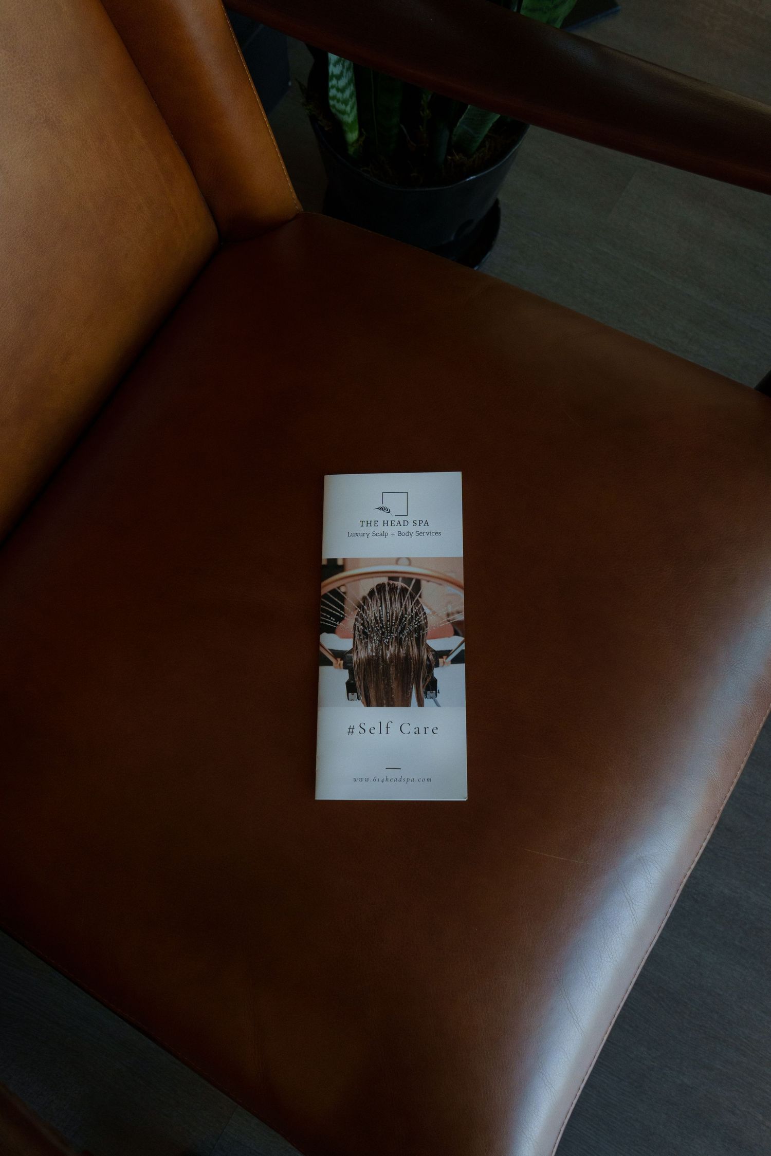 Close-up view of a brown leather massage table or treatment bed in a spa setting.