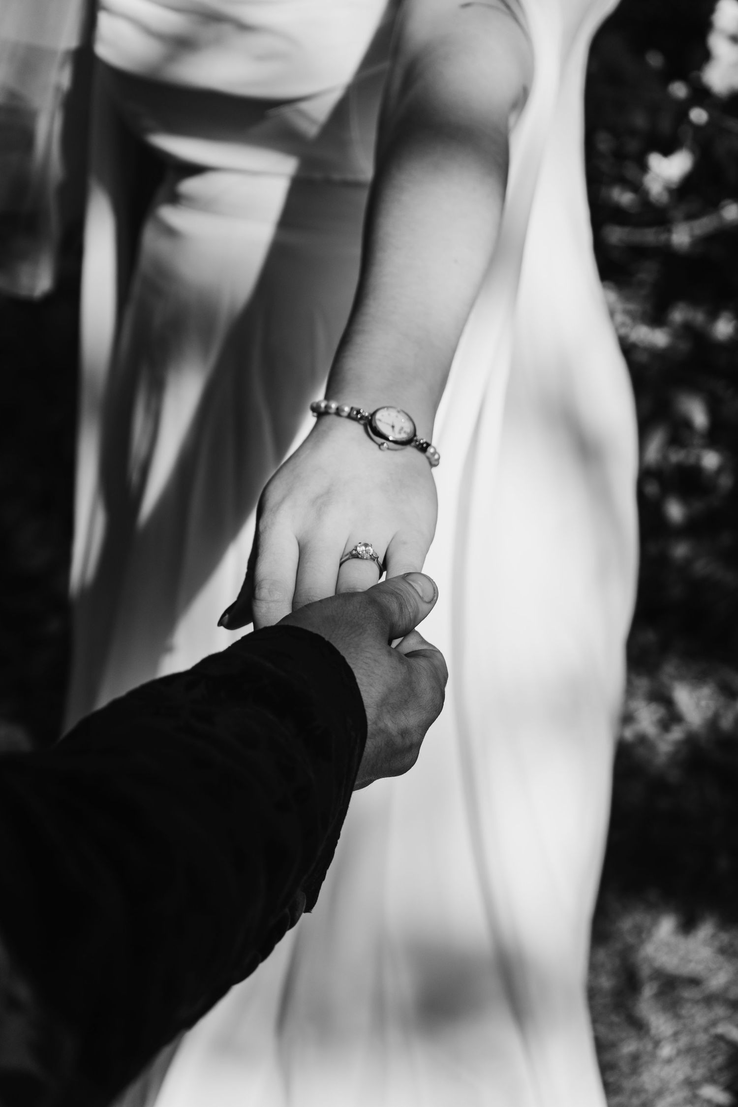 Black and white photo sequence showing a hand placing an engagement ring on another person's finger during a proposal.
